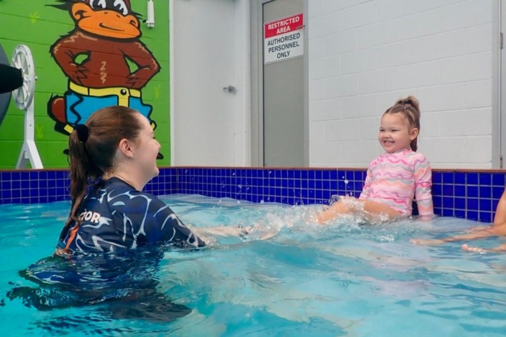 swim instructor guides children