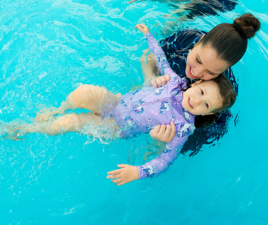 Instructor helping a child float on their back during a swimming lesson
