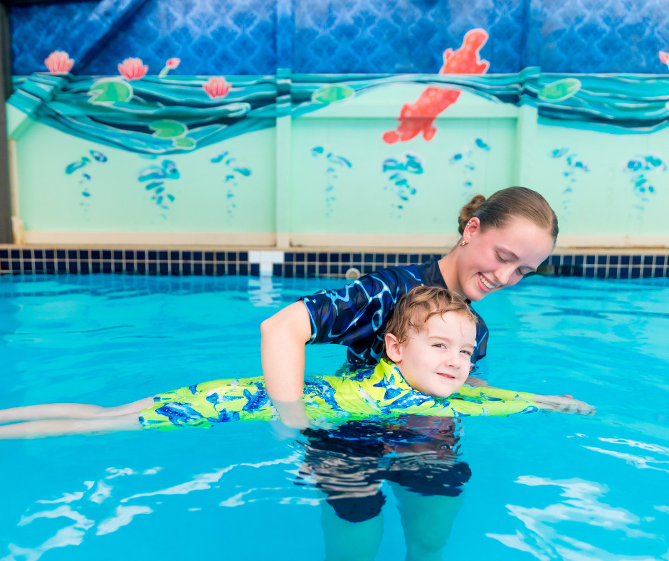 Child learning to swim with instructor support in a calm pool setting