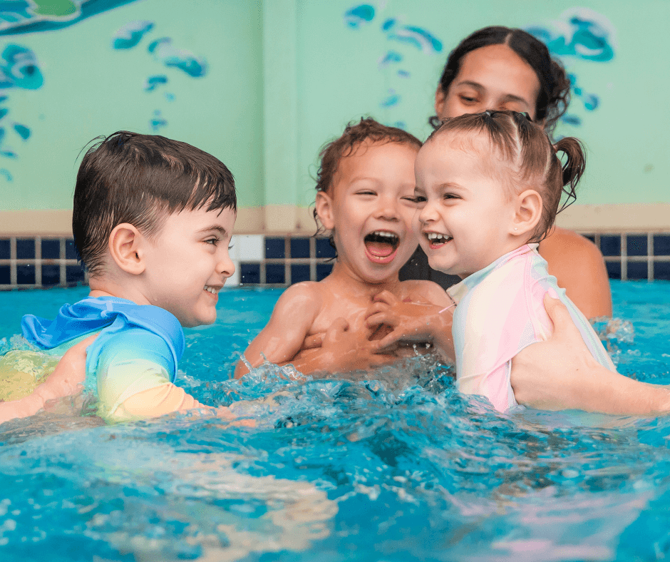 Three children practising swimming during a first swimming lesson