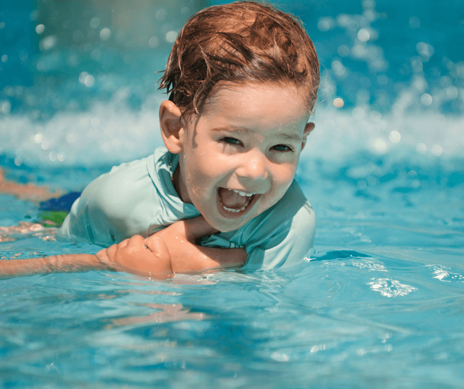 Toddler swimming in a pool during their first swimming lesson
