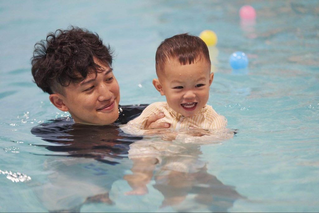 Parent swimming with infant during a baby swimming lesson